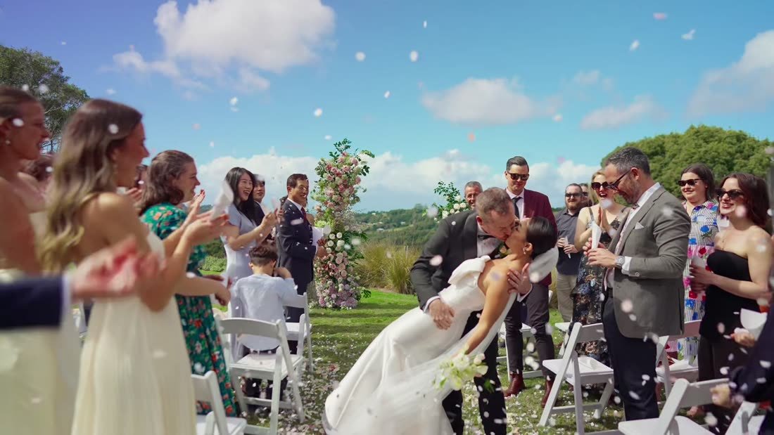 Guests throwing confetti as the couple walks the aisle